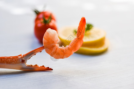 海鲜鱼产煮螃蟹爪上的虾海洋美食晚餐和白桌底番茄柠檬图片