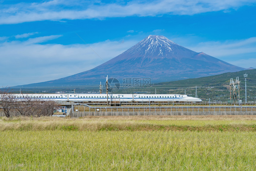 Shinkansen列车快速驾驶和通过日本东京火车站附近的藤田山配有绿稻日本图片