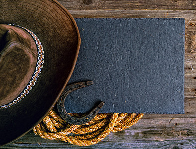 黑色粉笔板Lasso马蹄木和传统牛仔帽木制背景西部牛仔图片