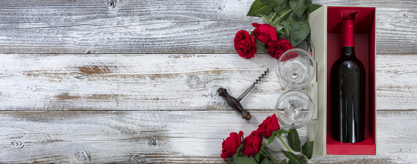 以红玫瑰和一瓶酒庆祝情人节图片