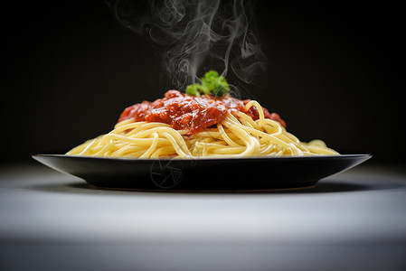 意大利面食在餐厅的黑盘上配有番茄酱和面食高清图片