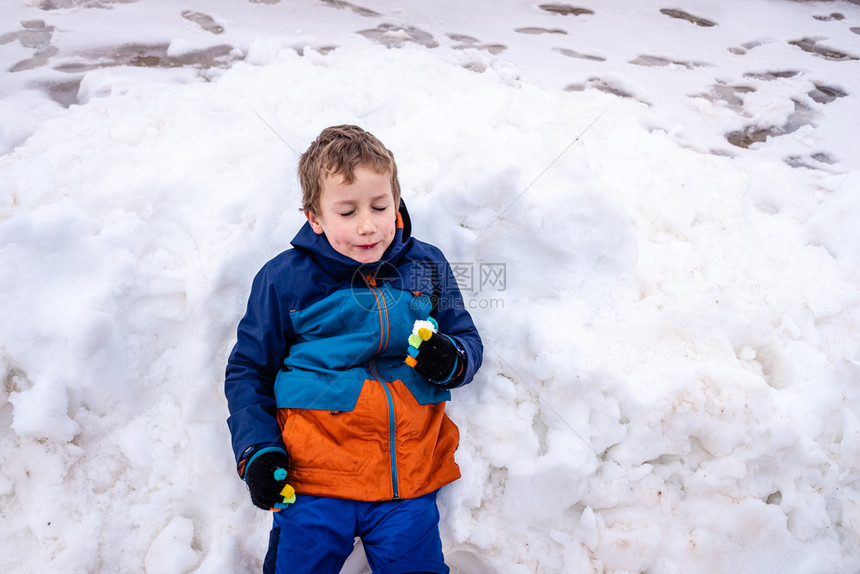 年轻男孩躺在雪地里放松图片