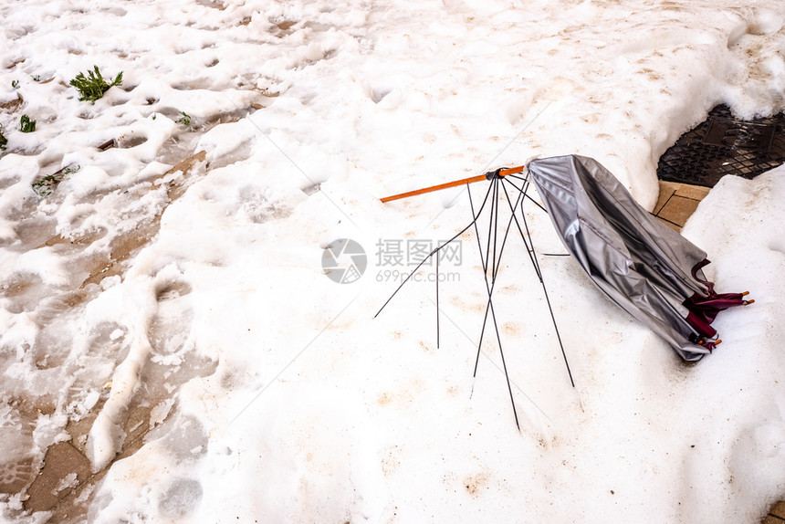 伞被风吹到雪地上的一条小街粉碎了图片