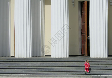 一个小孩子的身数爬上楼梯旁边的大柱子图片