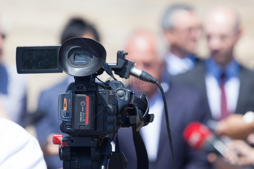 记者招待会上的电视摄像机背景中模糊的政治家或商人图片