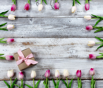 母亲节快乐假期概念与棕色礼品盒和白生木背景粉红郁金香边图片
