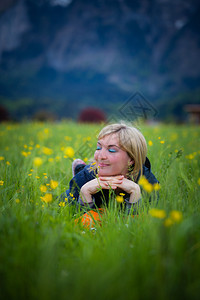 梦幻的金发女孩躺在绿草地上图片