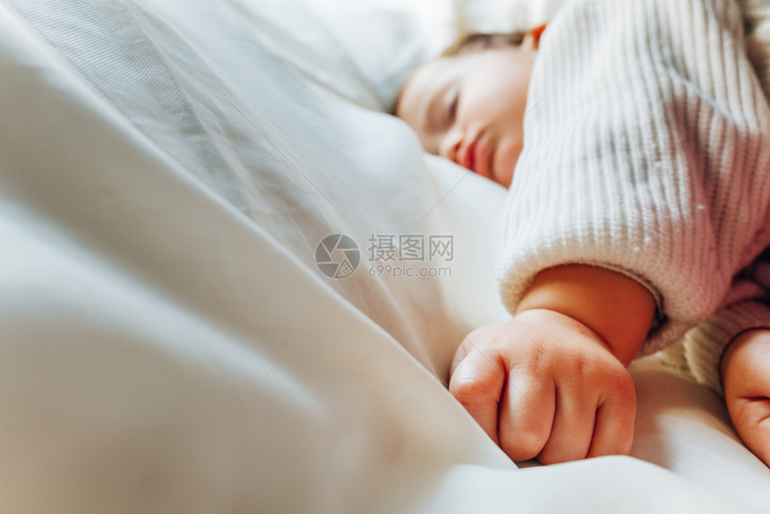 关闭婴儿和的手在午睡时觉孤立在白纸上图片