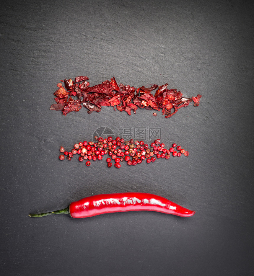 黑色石背景的红辣椒图片
