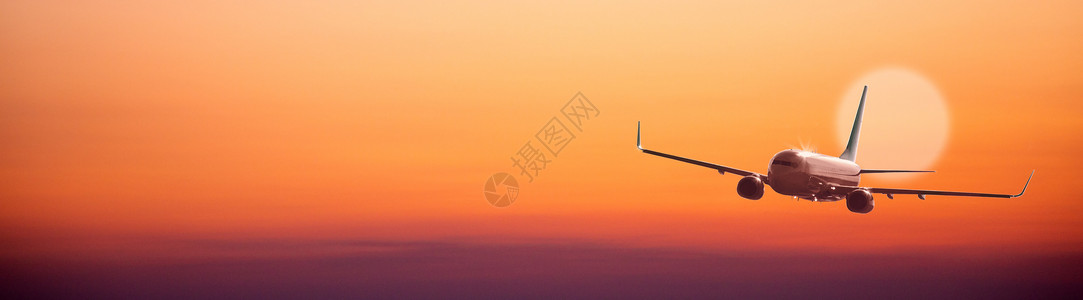 在日落天空背景下飞行的飞机图片