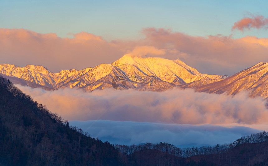 太阳天亮时从雾中观察雪山自然景观图片