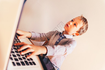 和电脑一起工作的孩子在他业务集中打字成功有趣的图像图片