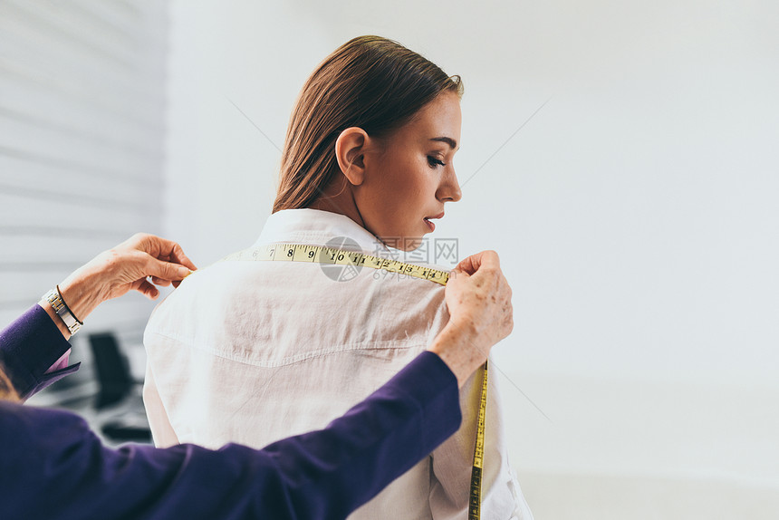 时装设计师工作室测量纺织材料剪布由女设计师时装表演室女设计师从事专业工作测量车间裁缝模特女服装图片