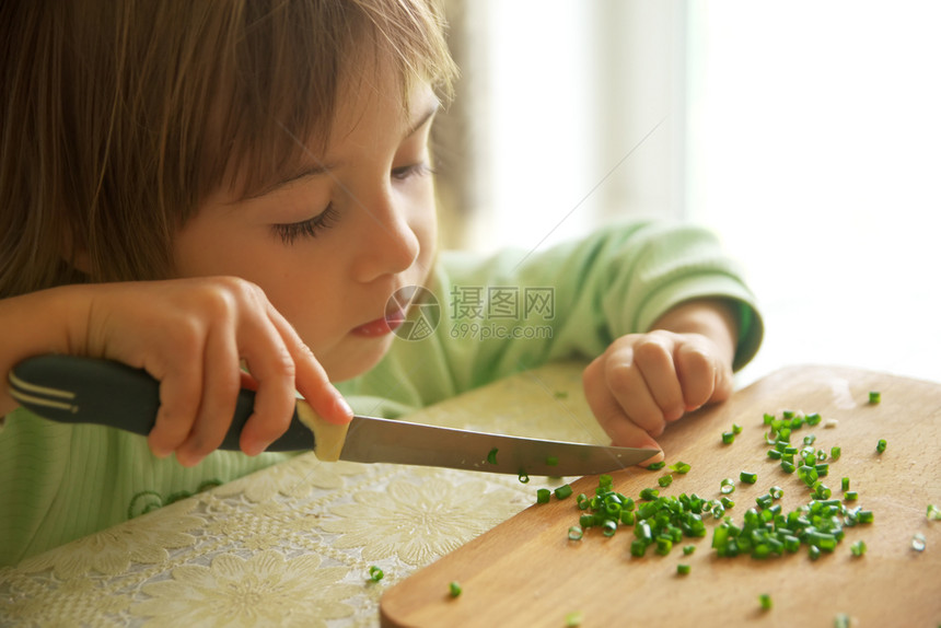女儿用刀割绿洋葱准备食物和烹饪现场图片