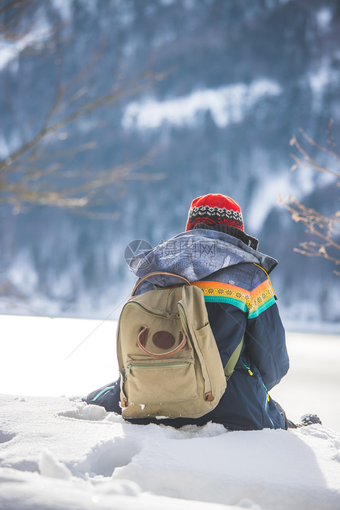 美丽的高加索女孩正坐在雪中冬季风景奥地利图片