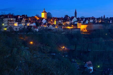 德国南部巴伐利亚州罗德堡的中世纪老城区屋顶塔楼和城墙的夜空中观察图片