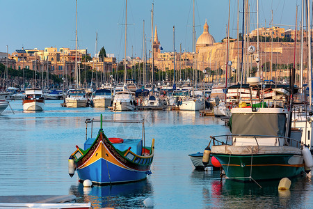 斯泰港瓦莱塔港马耳他有游艇和多色渔船的瓦莱塔港Luzzu眼睛教堂和堡垒由日落光照亮马耳他背景