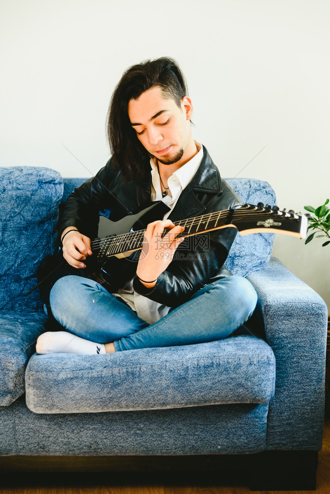 穿着白衬衫的吉他手肖像和享受他正在演奏的音乐表情图片