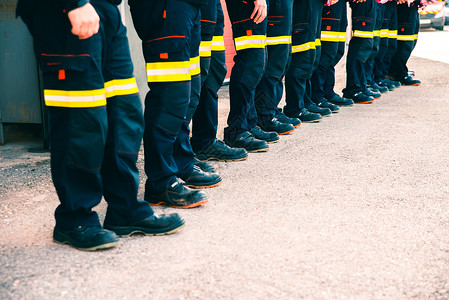 消防部门一群穿着工作制服的消防队员在团工作背景