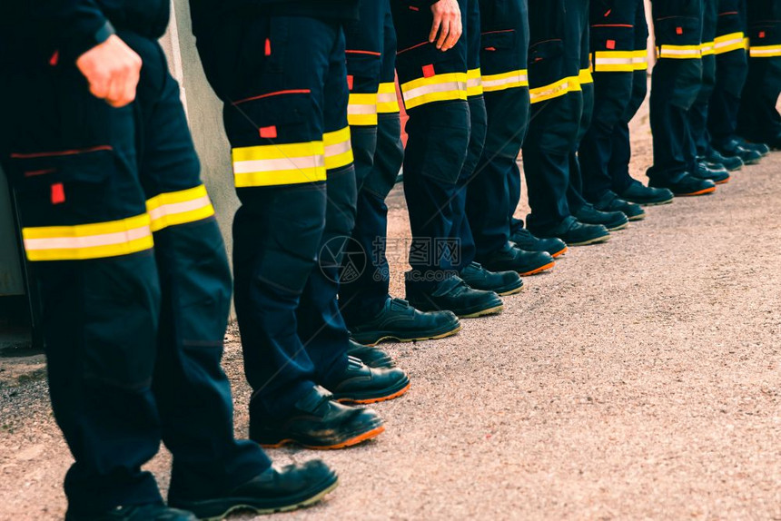 许多无法辨认的消防员排成反射裤图片