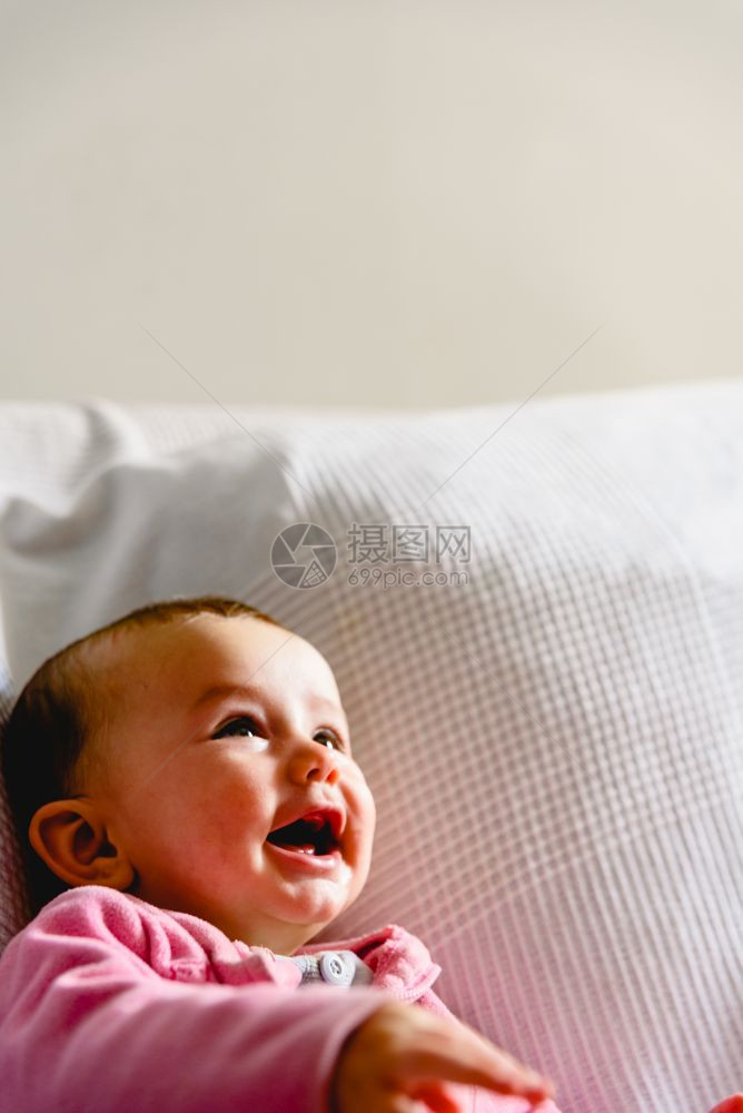 可爱有趣的女婴带着粉红色睡衣微笑图片