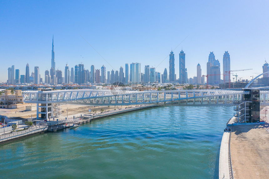扭曲桥的空中视图湖或河的建筑结构迪拜下城天线阿拉伯联合酋长国或阿金融区和蓝色天空的城市商业区图片