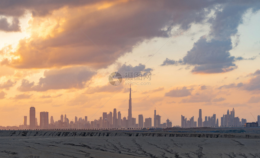 迪拜市中心有沙漠阿拉伯联合酋长国或阿金融区和商业位于智能城市日落时有天梯和高楼图片