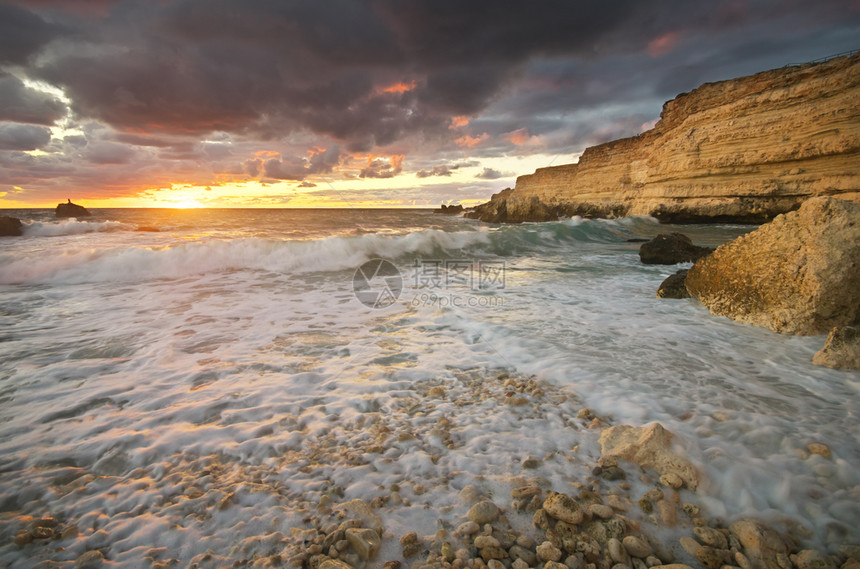 美丽的海景日落时和岩石自然的构成图片