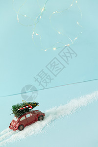红玩具车有圣诞树红玩具底蓝色有圣诞节灯光新年贺卡假日概念图片