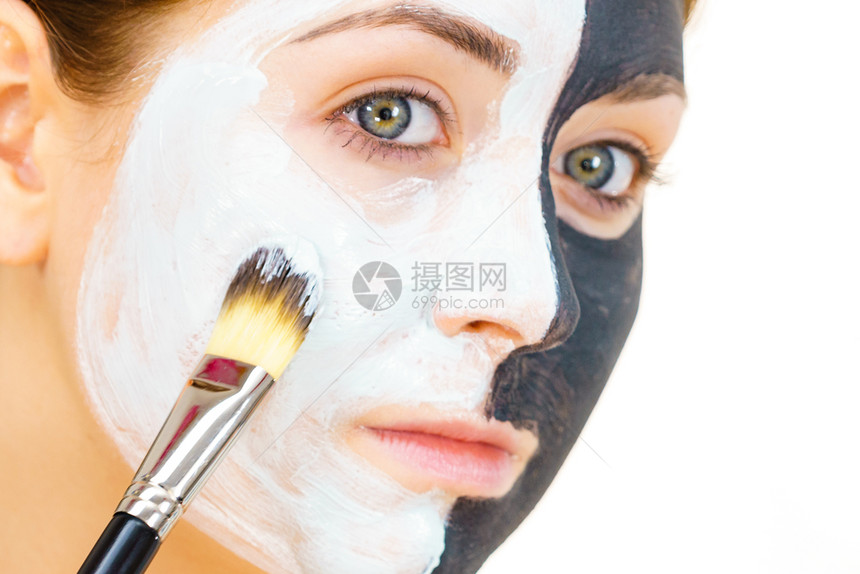 白泥涂在干净的皮肤上女孩照顾油色的皮肤美容程序皮肤护理黑脸涂在白色的上图片
