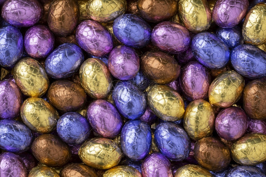 巧克力东蛋在彩色的锡质油中关闭整个框架图片