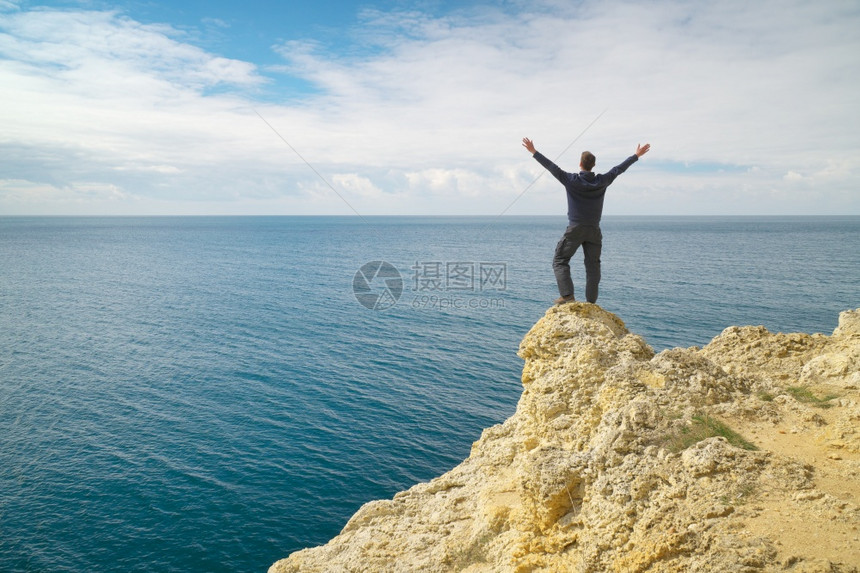 人类在海悬崖边缘概念和情感的场景图片