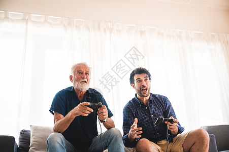 两代快乐双男人家庭老父亲拥抱年轻成儿子享受游戏快乐图片