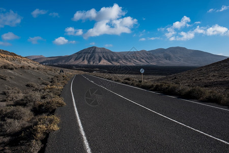 埃扎罗在兰萨罗特的加那利岛有公路的火山景观背景