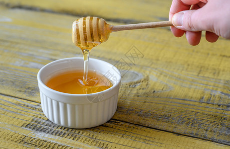 木背景的一碗蜂蜜图片