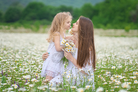 快乐的母亲和女儿在大卡莫米尔山地草原上情感爱和照顾的场景背景