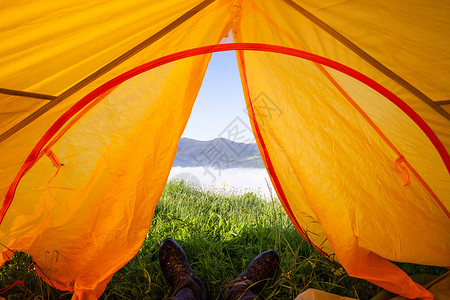 从观光帐篷到山的观光景象穿靴子的人躺在地毯上图片