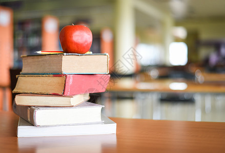 一个苹果放在桌上的书架放在图馆上背景教育学习概念书集图片