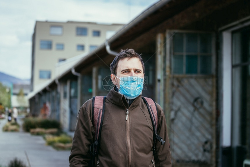 在户外的年轻人戴着面罩科罗纳和流感季节图片