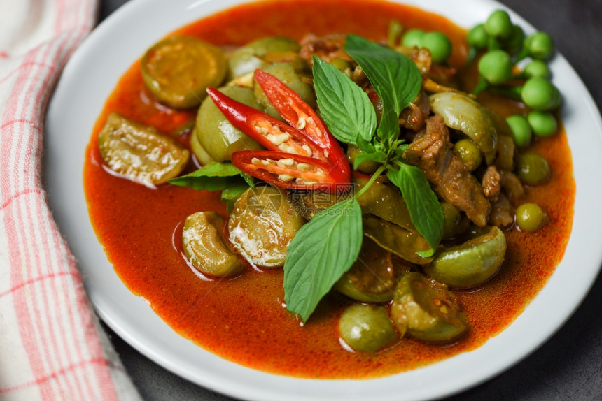 白盘上泰国咖喱汤红猪肉烹饪图片