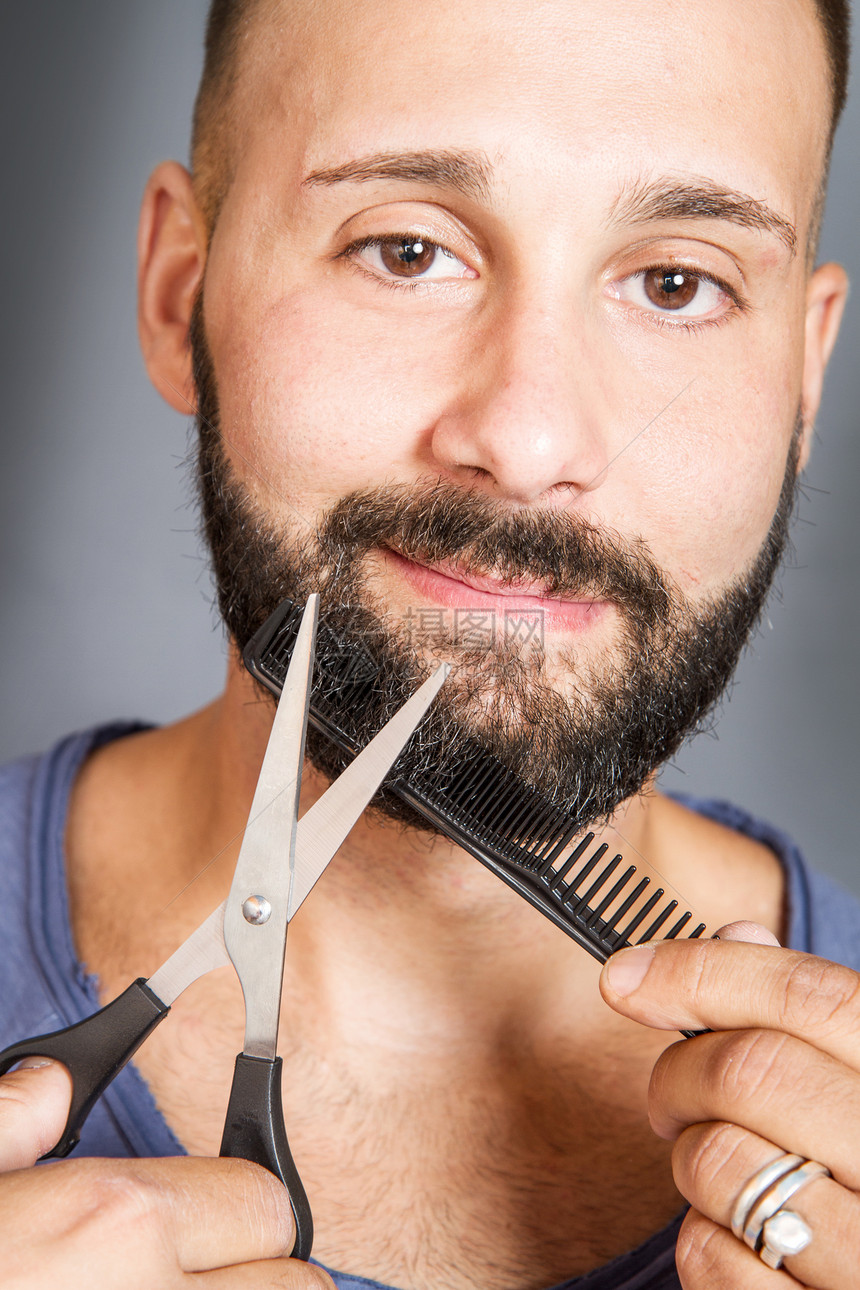 一个用剪刀梳胡须的男人肖像图片