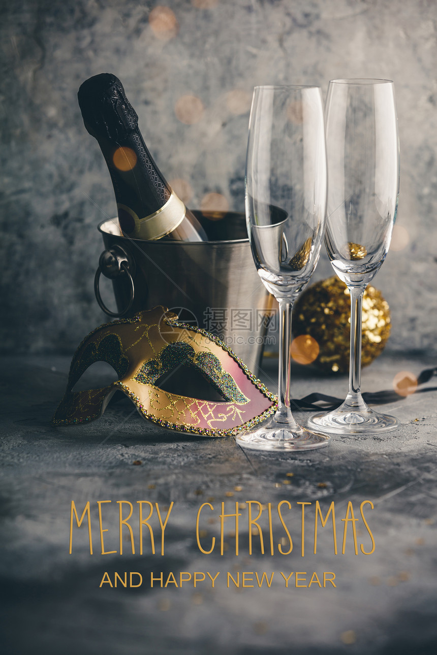 装有冰眼镜和混凝土背景的圣诞装饰品桶里香槟瓶图片