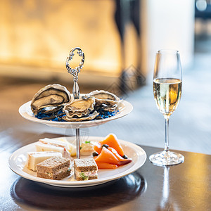 欢迎鸡尾酒大餐新鲜牡蛎和熏鲑鱼海鲜菜配上闪亮的香槟图片