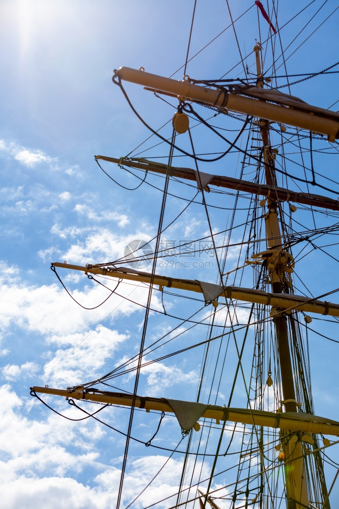 航行期间在帆船顶上详细拉吊在蓝色天空中拍摄海洋物体概念帆船顶上拉吊的详细紧图片