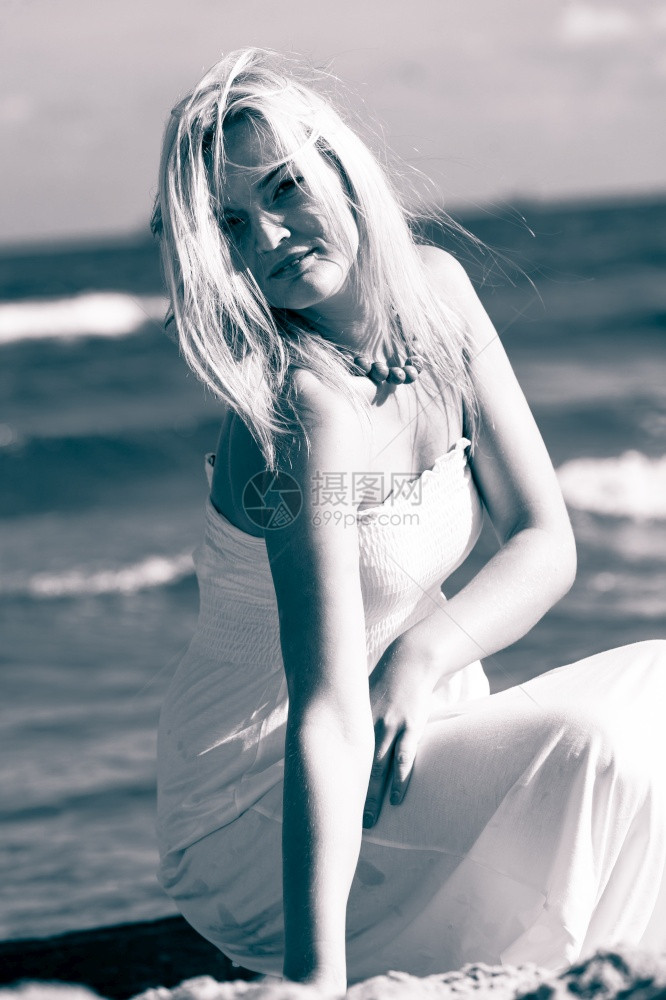 阳光明媚的海滩上美丽女人站在海上的年轻女孩自然户外放松休闲概念图片