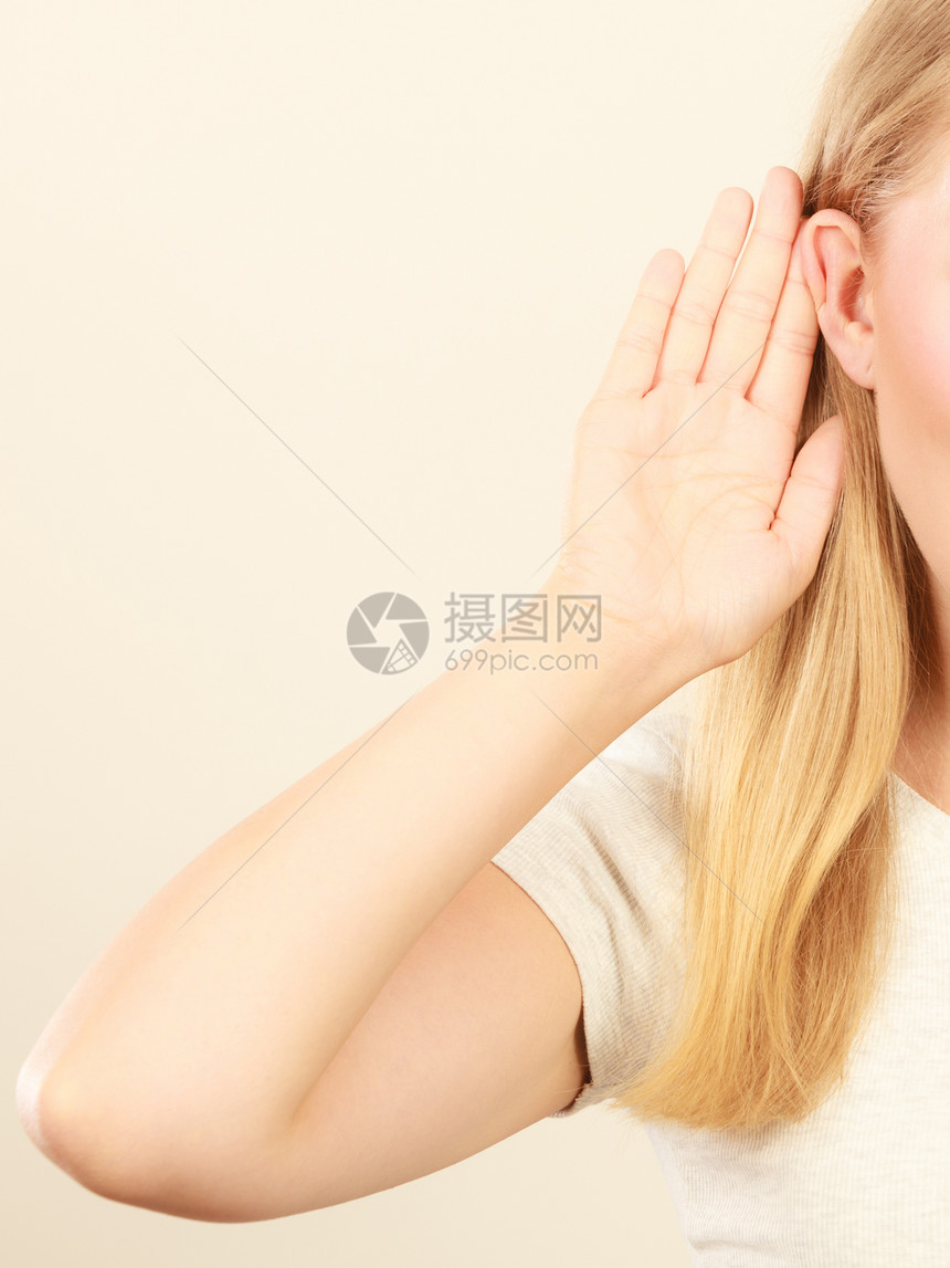 Gossiprumorswhiors耳语听力概念金发年轻女人用手耳朵听好工作室拍摄在白色背景上工作室拍摄妇女用手耳朵听好图片