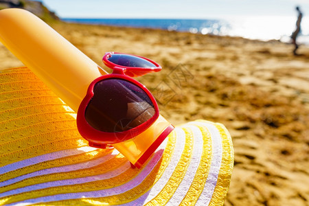 红太阳镜黄草帽和沙滩防晒霜奶油瓶夏天和假日图片