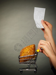 妇女手拿着小面包和收据单手拿着面包和账单图片