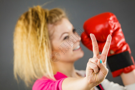 身着红拳击手套的运动快乐妇女表现出积极的姿态和平图片