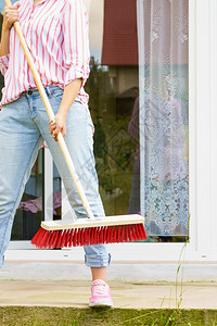 使用大扫帚清理后院子的妇女使用扫帚清理后院子的妇女图片